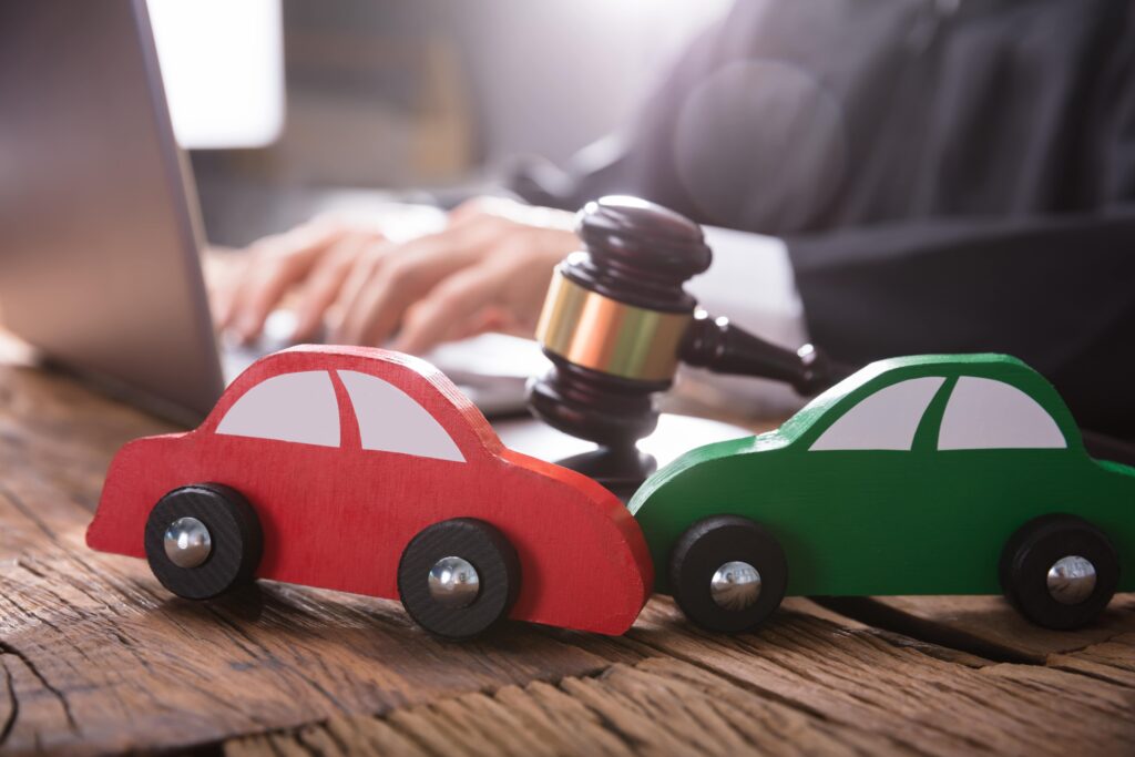 Two toy cars next to judge's gavel